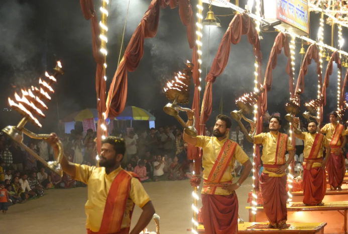 Priests performing the grand Ganga Aarti with large brass lamps at Dashashwamedh Ghat in Varanasi during a 2026 evening ritual.