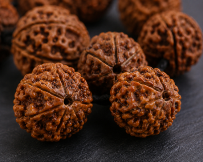 Close-up of authentic Rudraksha beads displaying natural Mukhi lines and texture.