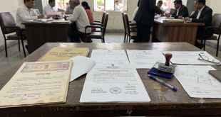 Official land record documents and property deeds laid out on a table representing the UP property mutation process Dakhil Kharij