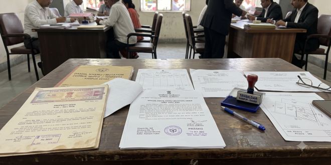 Official land record documents and property deeds laid out on a table representing the UP property mutation process Dakhil Kharij