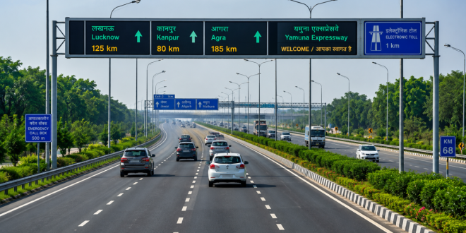 Multi-lane modern expressway in Uttar Pradesh with clear road markings, digital overhead signage, and green belts, demonstrating India's high-speed highway connectivity network.