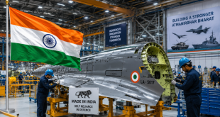 Indian flag fluttering next to an indigenously manufactured military fighter aircraft component inside a modern state-of-the-art defense industrial factory.