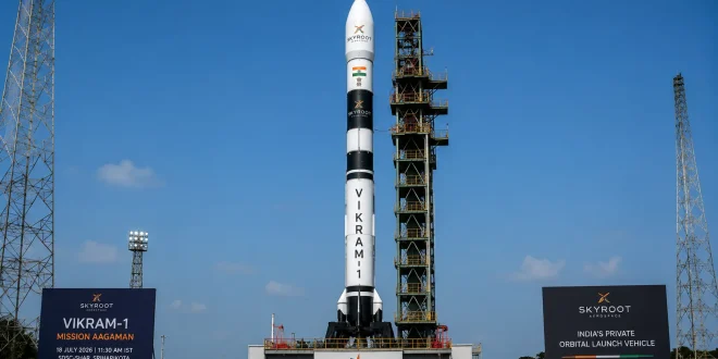 A sleek, seven-story-tall multi-stage Vikram-1 rocket by Skyroot Aerospace standing vertically on the launchpad at the Sriharikota spaceport under a clear sky.